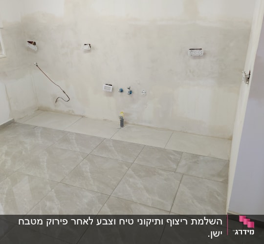 קיר עם חיבורים חשמליים וצנרת, רצפת אריחים חדשה
